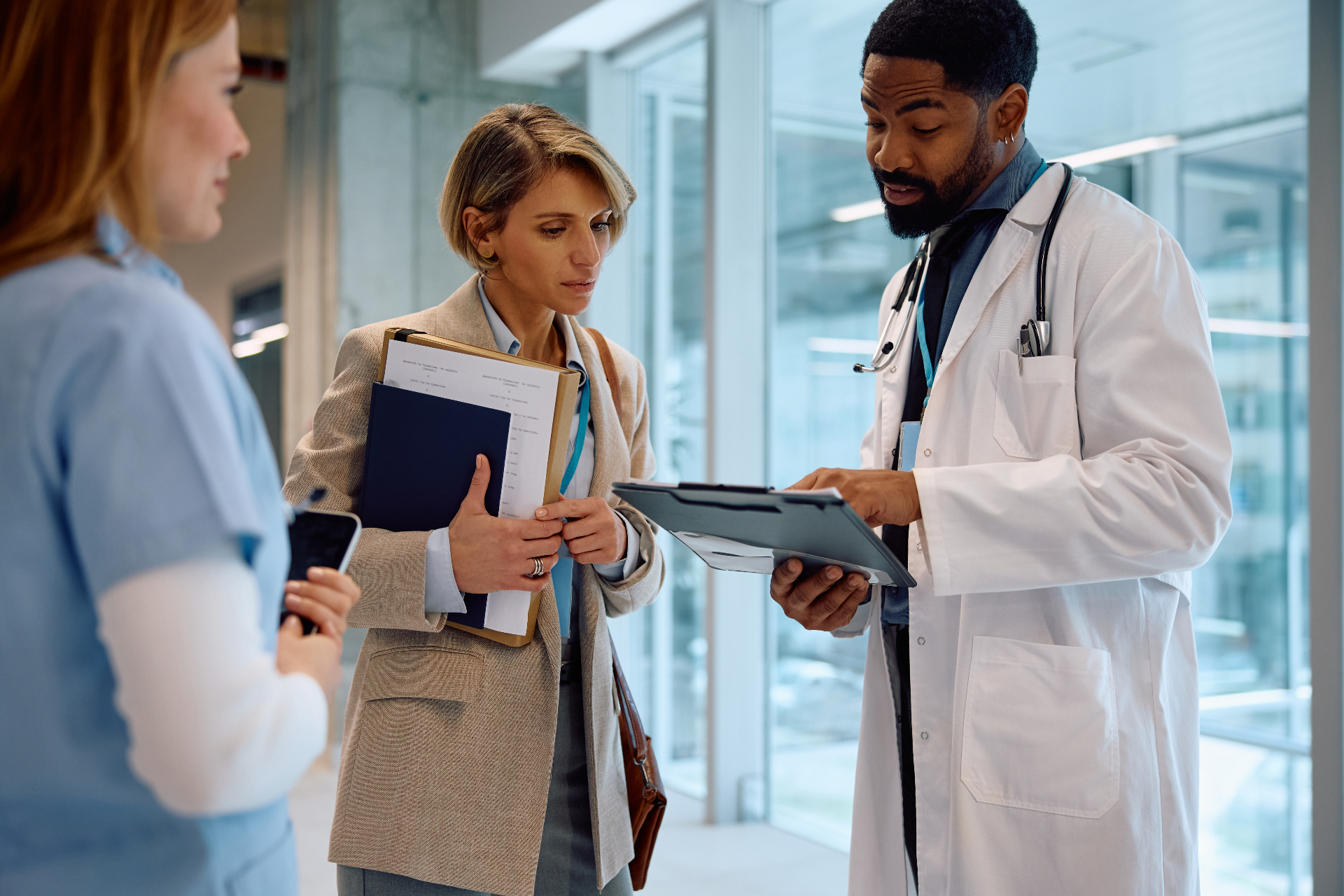 Medical professionals collaborating in a clinic hallway
